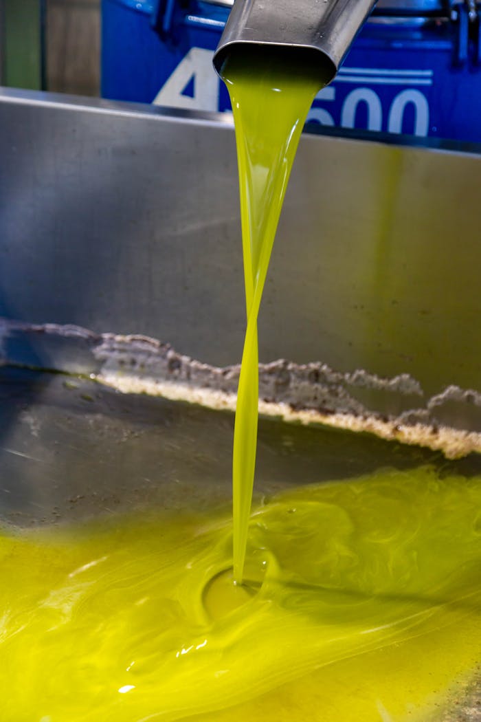 services-01 Fresh olive oil flowing from spout in a Puglia olive oil mill, showcasing traditional production.